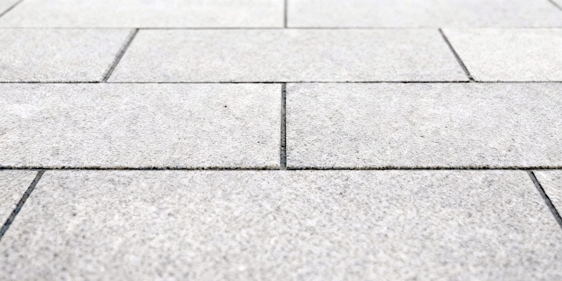 Nahaufnahme von Betonpflaster in einem Reihenverband mit Halbversatz